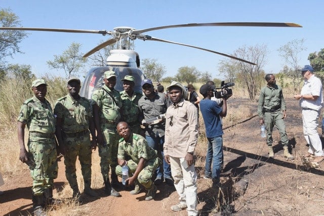 Game rangers standing in front of a helicopter